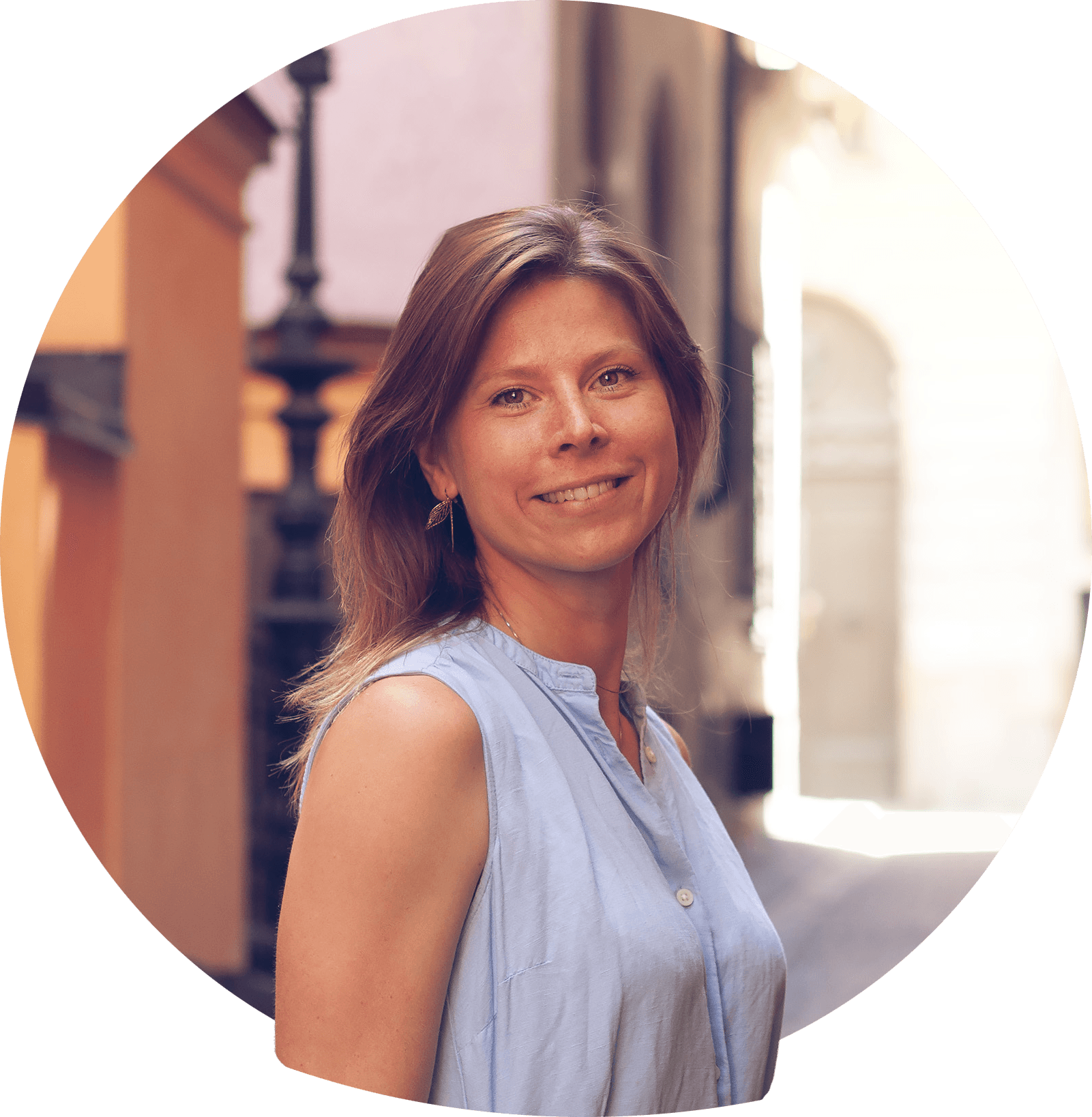 Frida F smilende med blondt skulderlangt hår i svart bluse med krage. Foto.