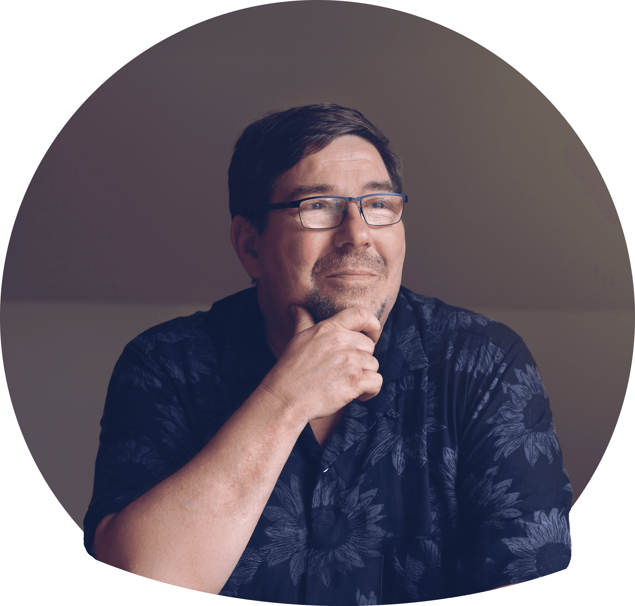 Raouf i lys blomstrete skjorte, mørkt brunt hår og kort skjegg. Har på briller. Foto.