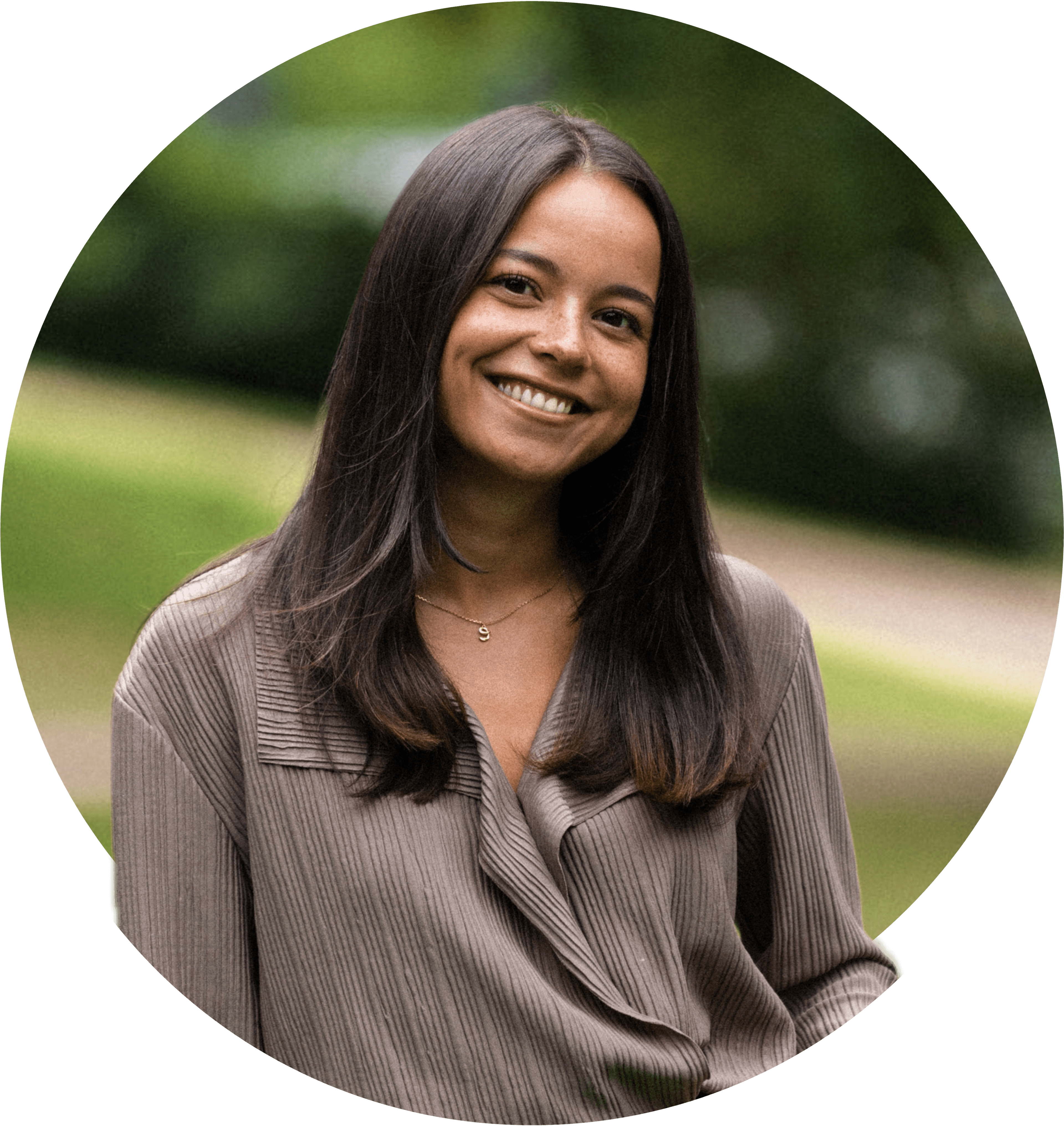 Elsa smiler bredt, iført lysebrun bluse, med mellomlangt brunt hår. Foto.